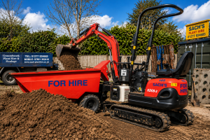 Mini dumper and excavator loading soil at a Sach Plant Hire yard in Essex with plant hire equipment and machinery in operation.